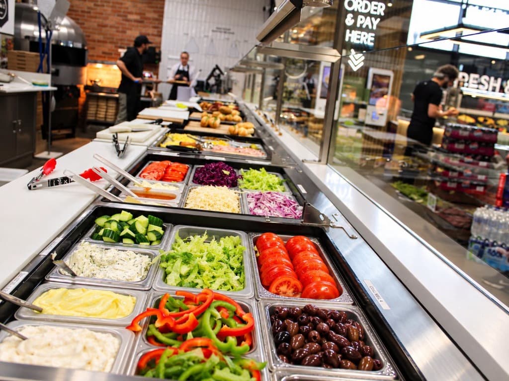 Triple 'a' Foodhall fresh salad deli bar with colourful crisp toppings and chefs in background